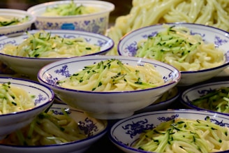 A colorful platter of various spicy noodle dishes served in bowls.