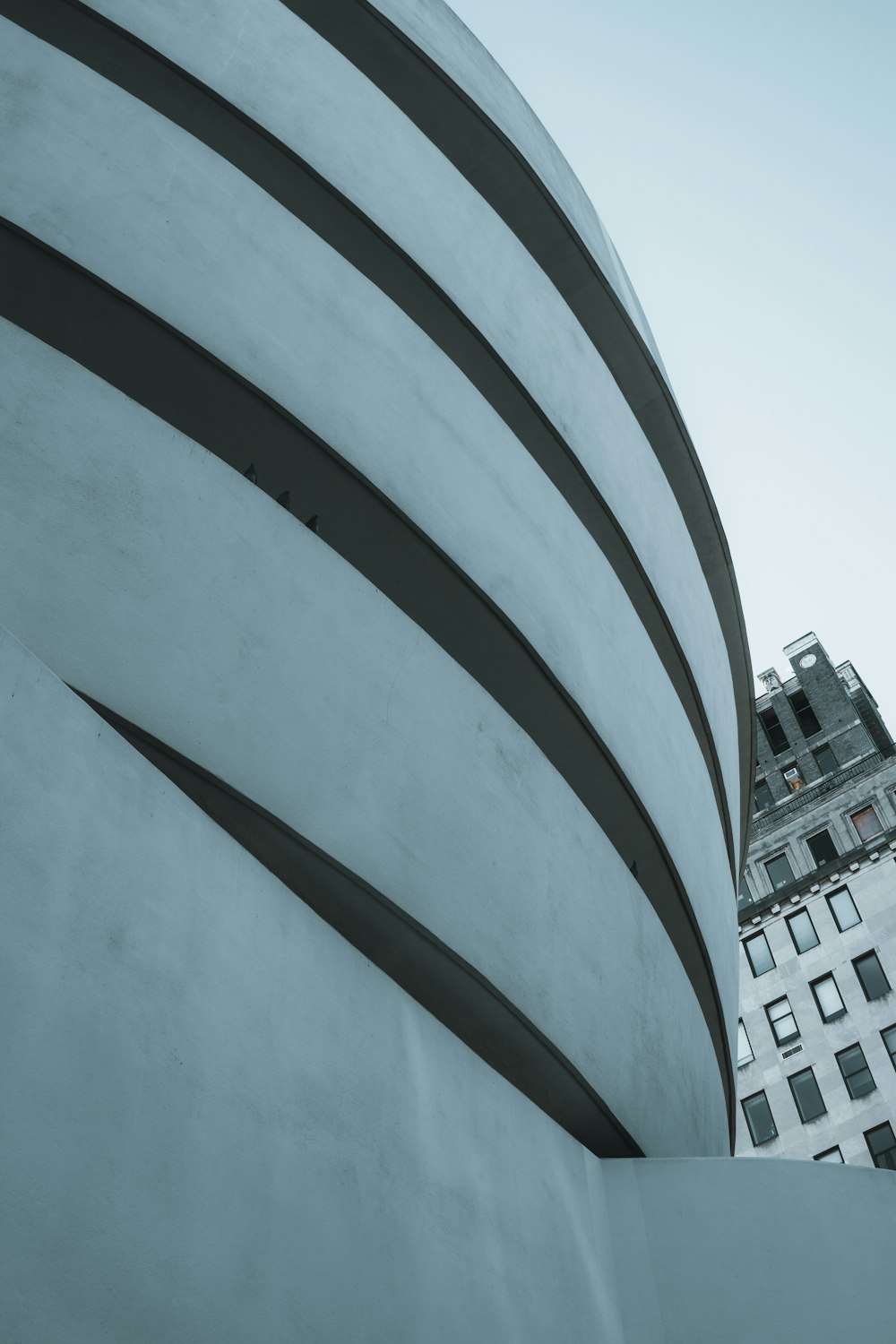 a tall building with a curved roof next to a tall building