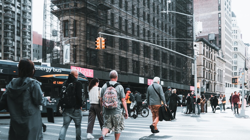 a group of people walking across a street