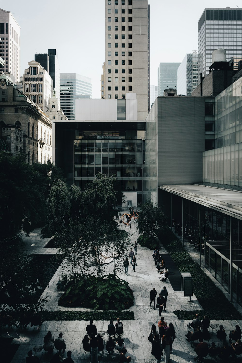 a group of people walking around a courtyard in a city