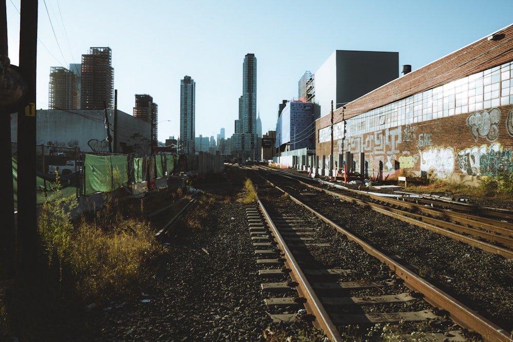 a train track running through a city with tall buildings in the background