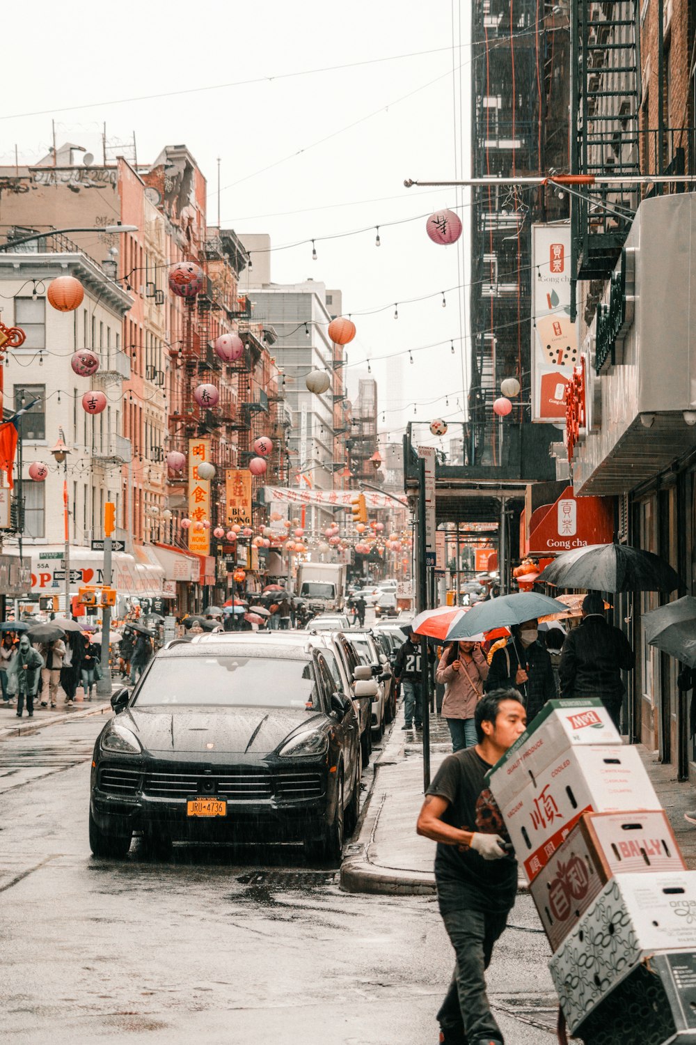 a man pushing a cart down a city street