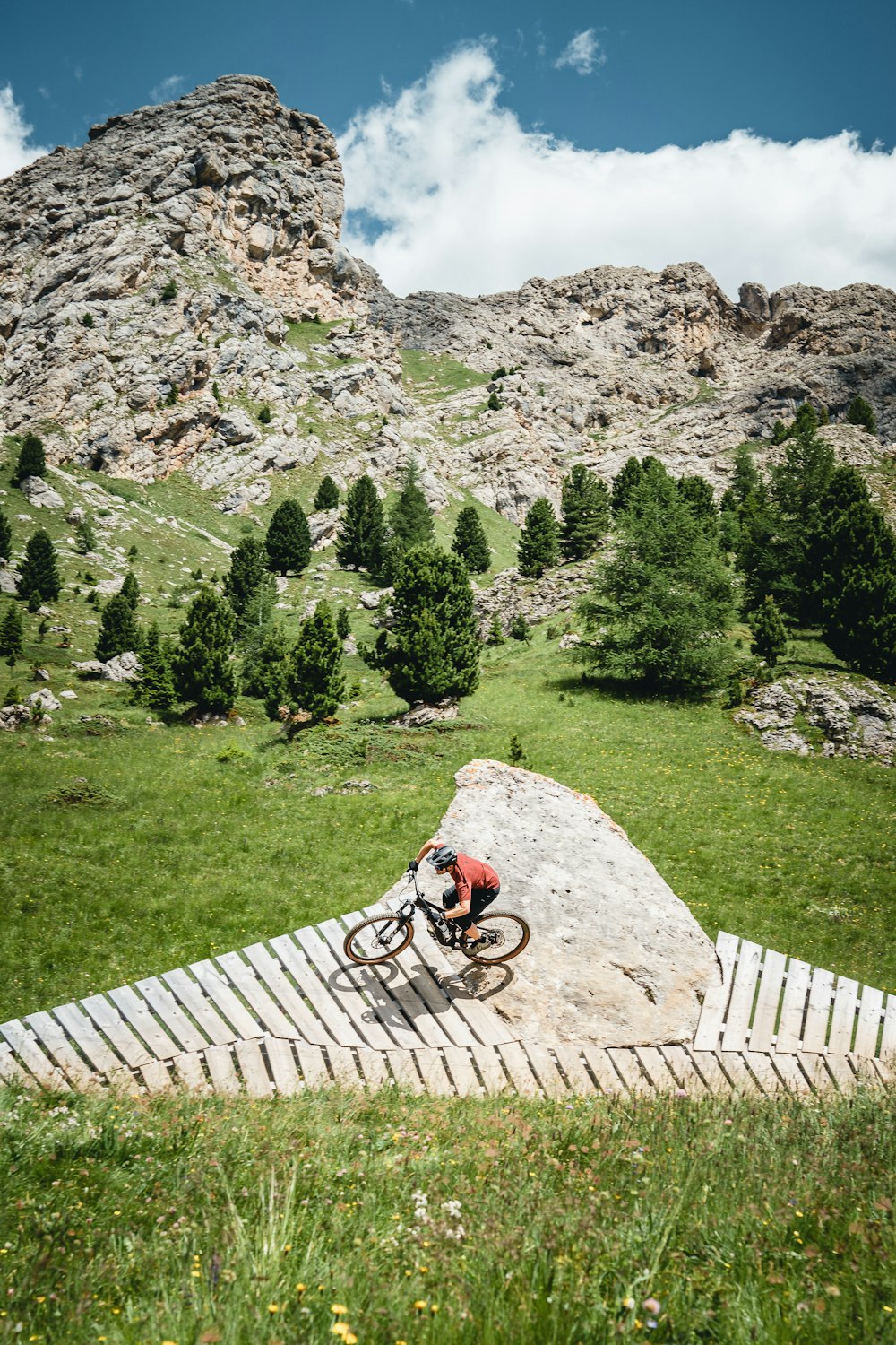 a man riding a bike down a wooden ramp