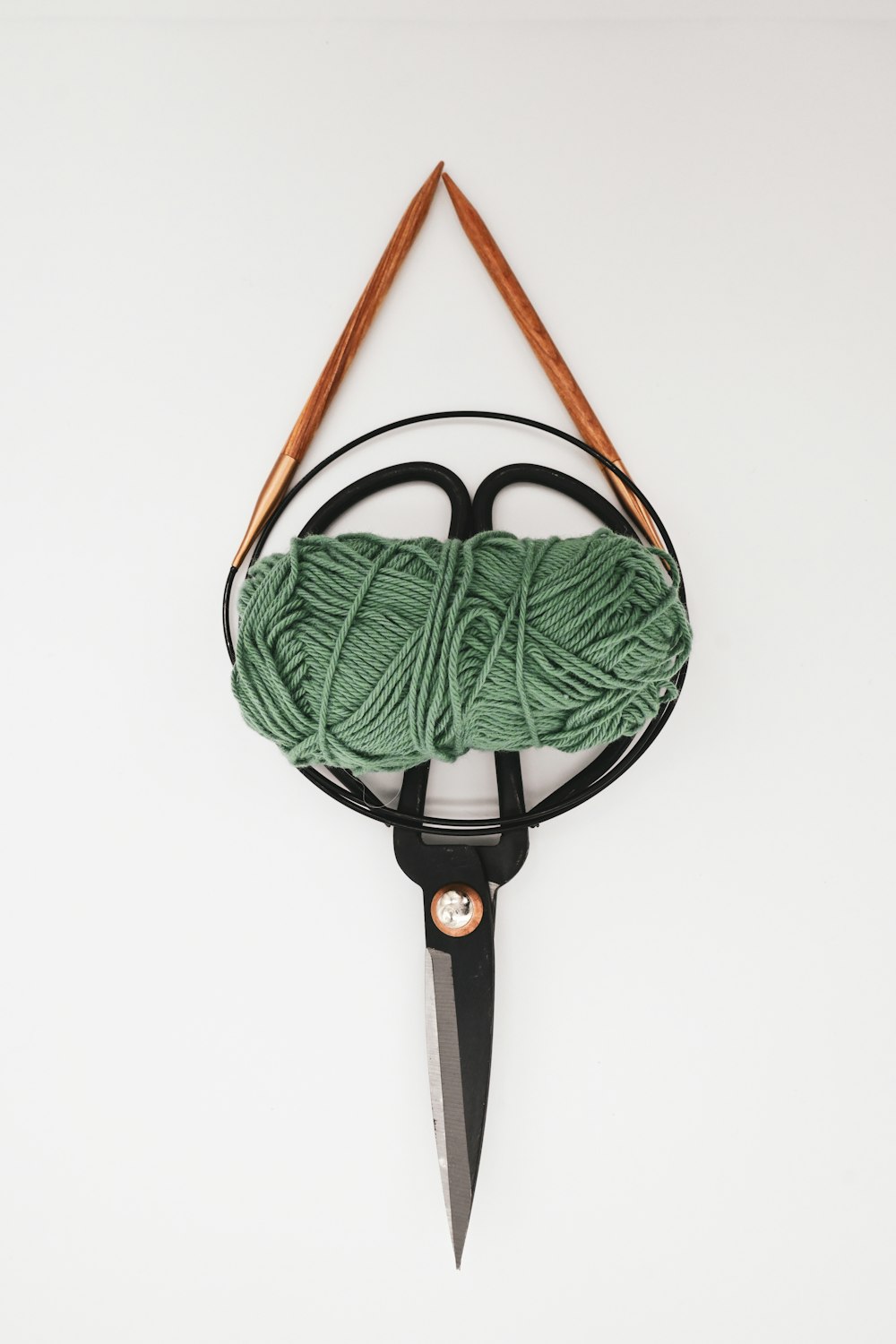 a pair of scissors and a ball of yarn on a hook