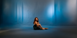 A serene portrait of Gretta in a softly lit room surrounded by calming blue and pink floral accents.