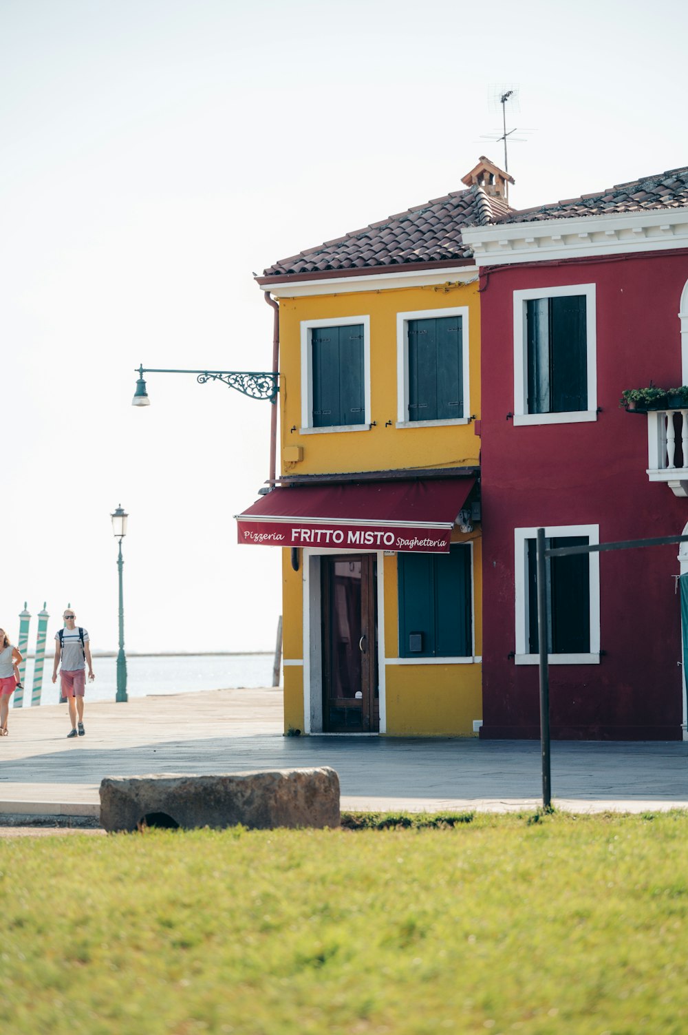 a red and yellow building with a red awning