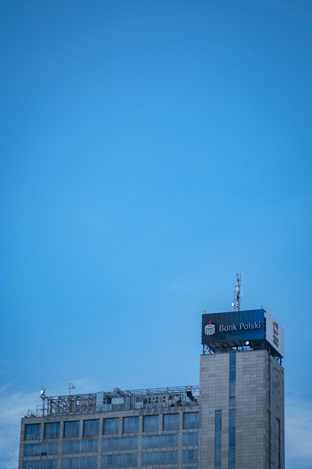 ein hohes Gebäude mit einem Schild auf der Spitze