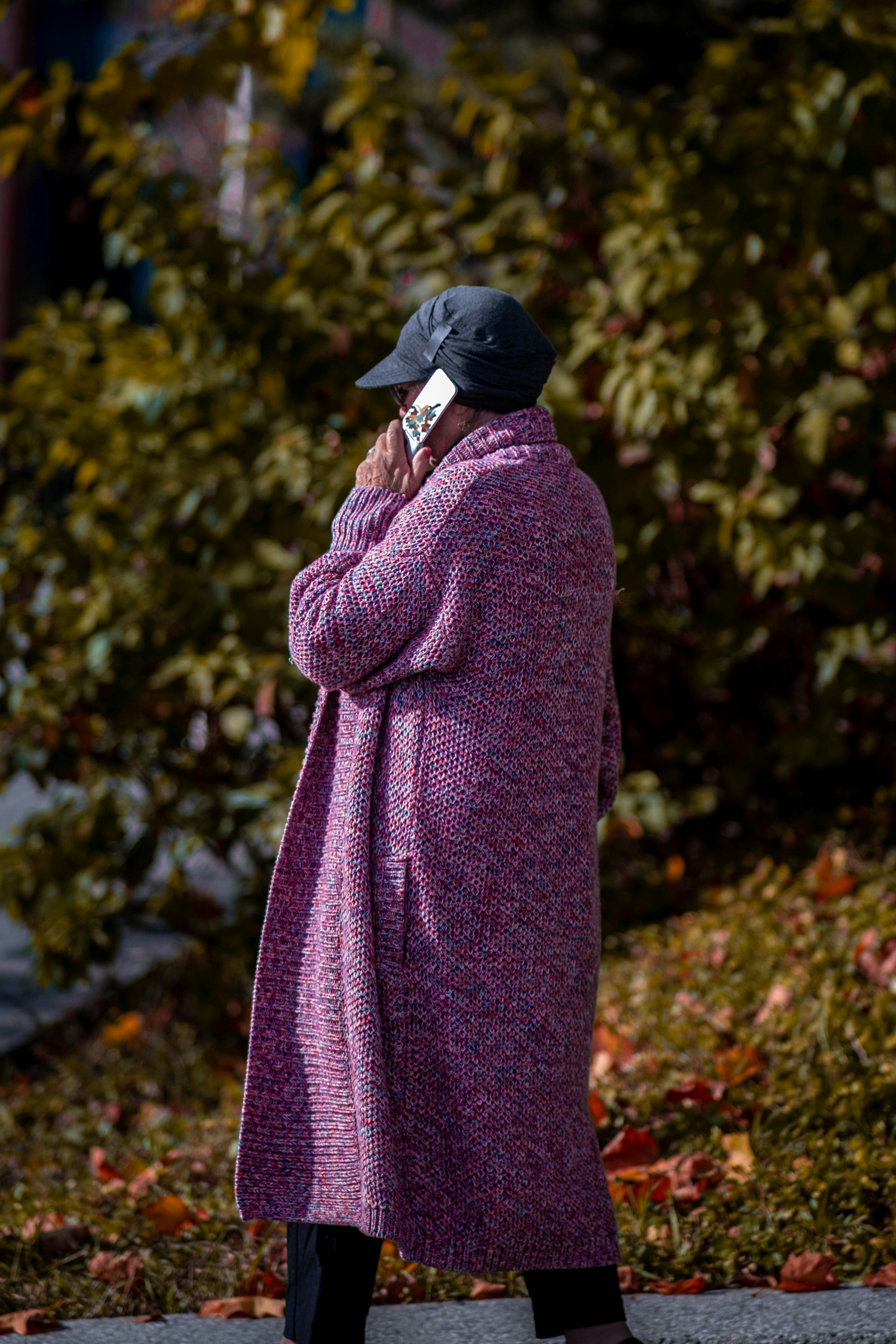 a woman in a purple coat talking on a cell phone