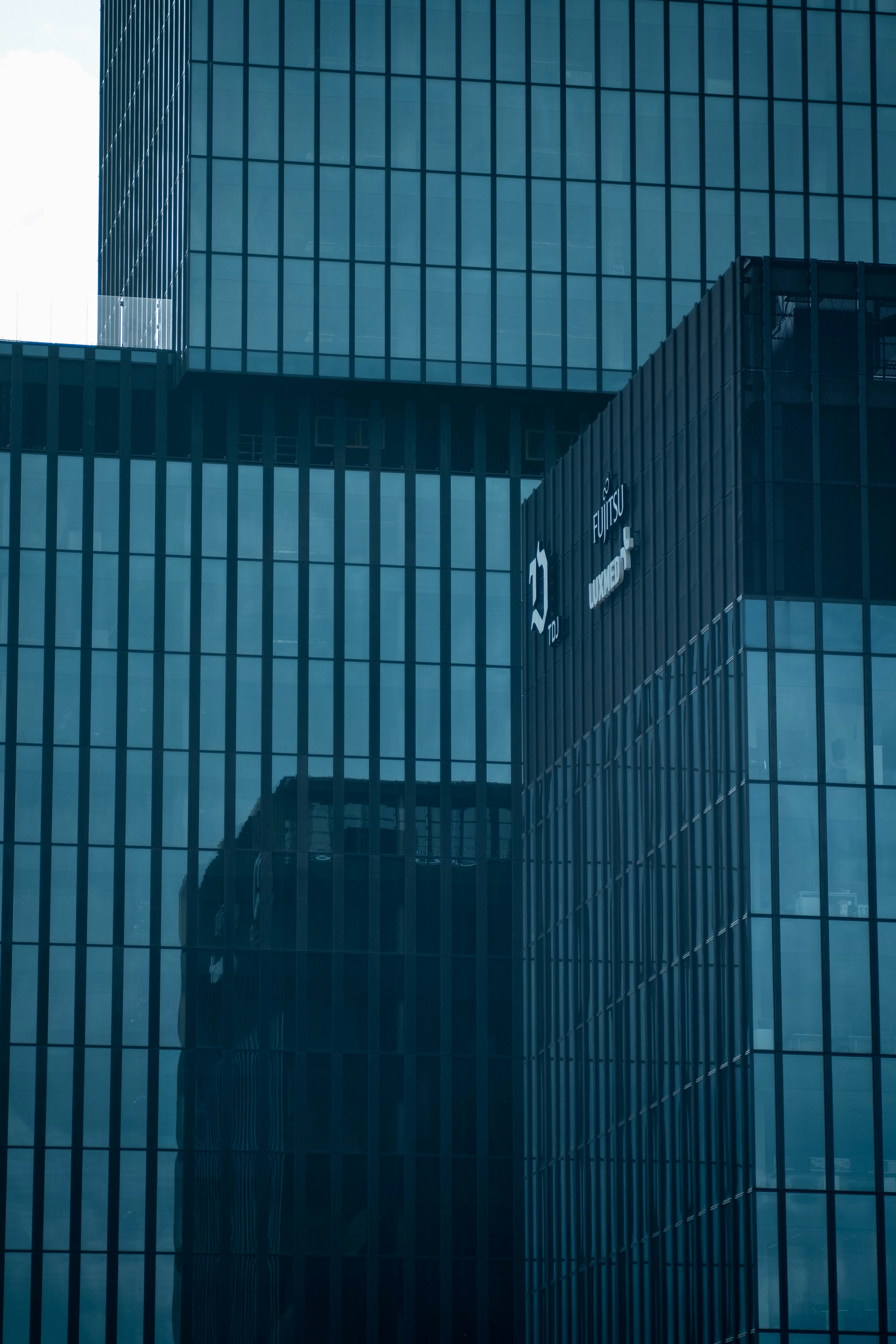 Edificios corporativos modernos de cristal con los logotipos de Fujitsu y Luxemburgo.