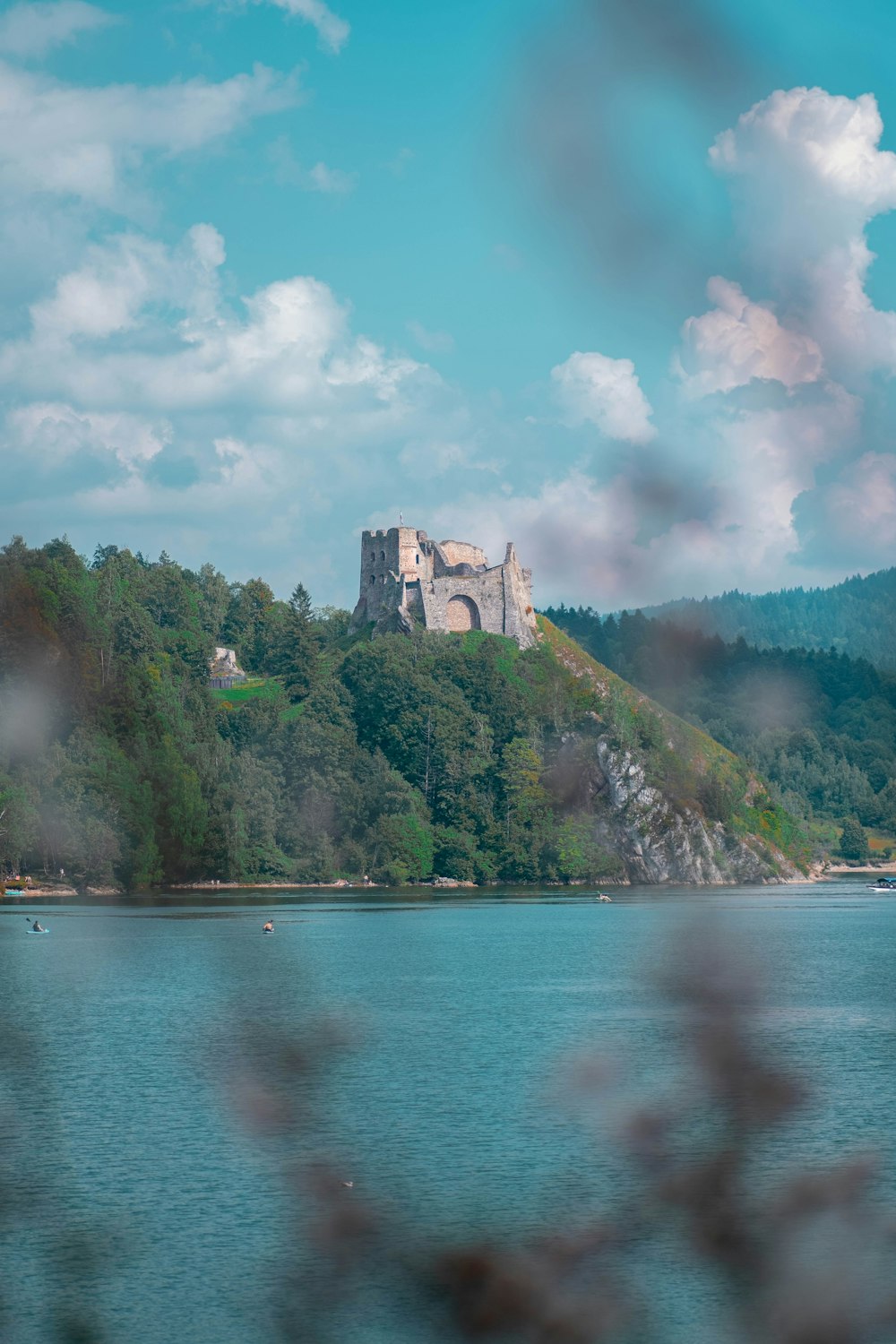 a castle sitting on top of a lush green hillside