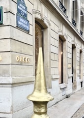 Wide angle view of a high-end store front showcasing metal and glass facade in daytime.