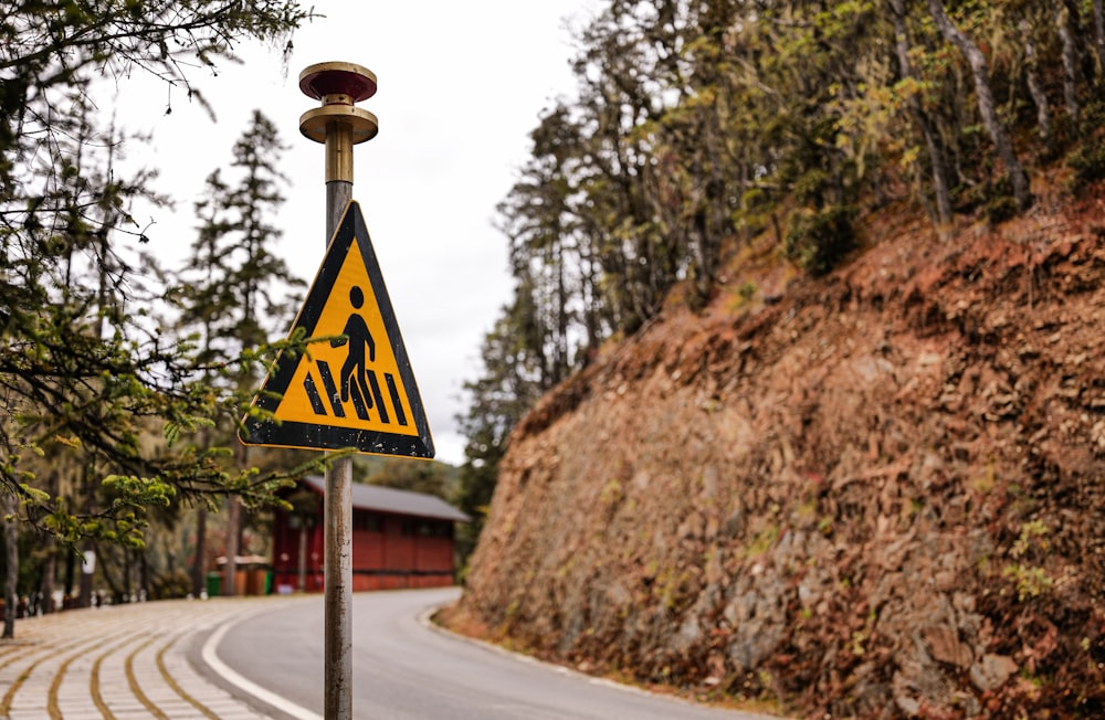 a yellow and black sign on the side of a road