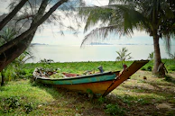 A rustic wooden boat resting on calm turquoise waters framed by lush greenery.