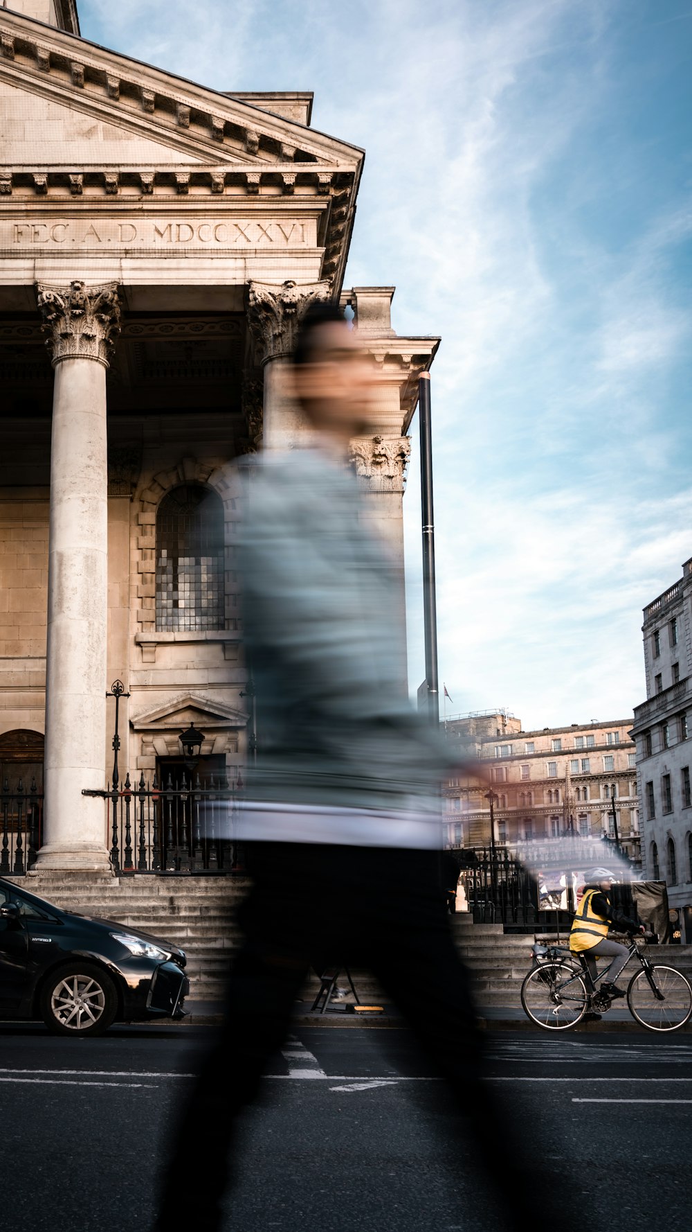 a blurry photo of a man walking past a building