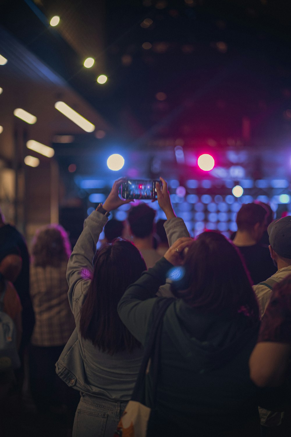 a group of people taking pictures with their cell phones