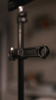 A close-up of a screen mount's secure clamp attached to a glass desk edge.