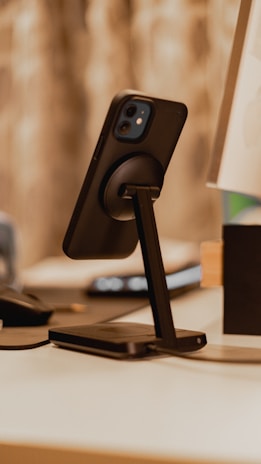 Stylish phone stand holding a smartphone at an angle on a desk.