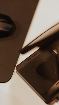 Close-up of a sleek Huion graphic tablet with pen on a minimalist white desk