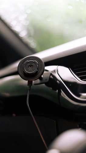 Magnetic phone holder attached to a car dashboard with a smartphone secured
