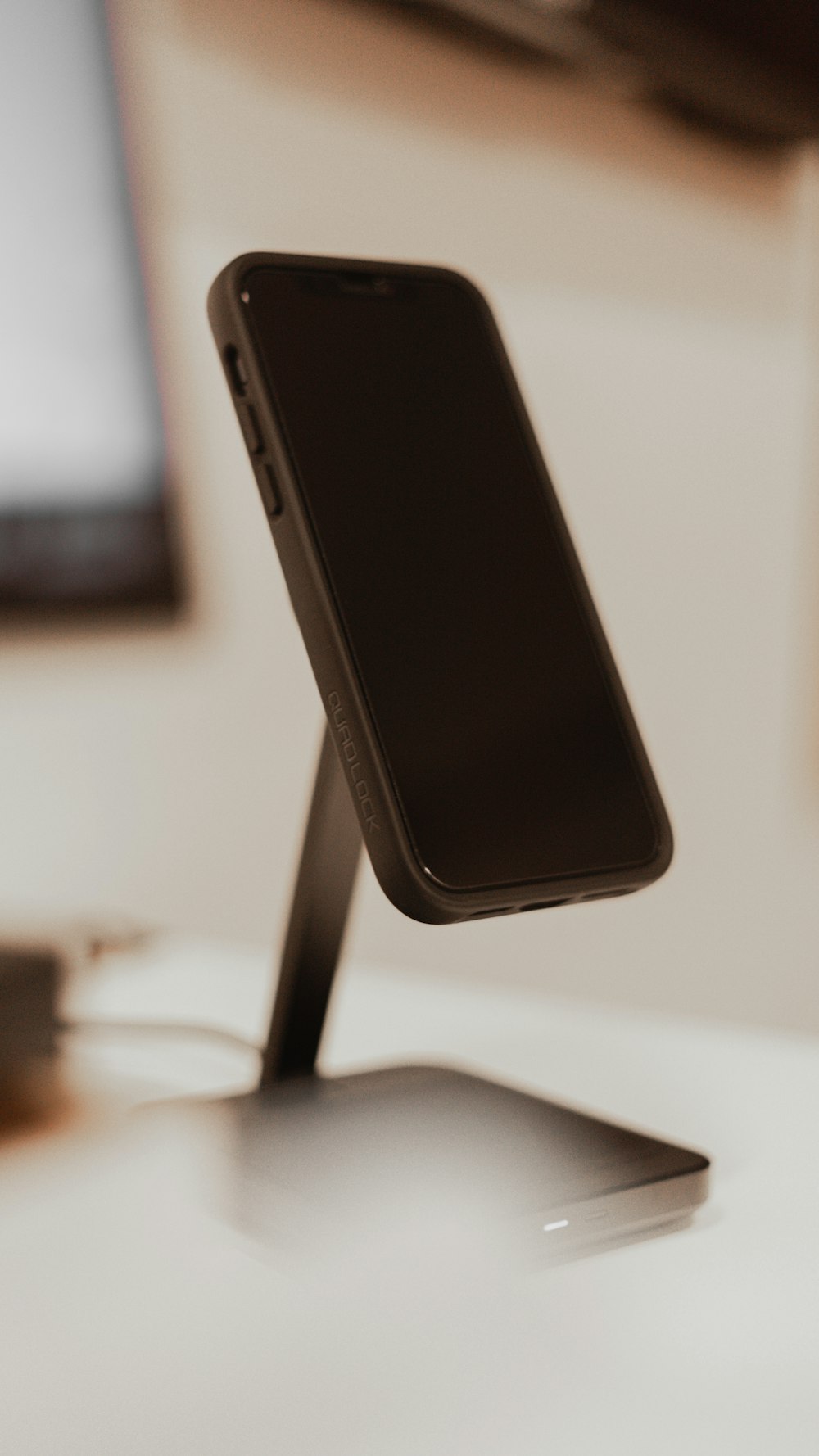 a cell phone sitting on a stand on a desk