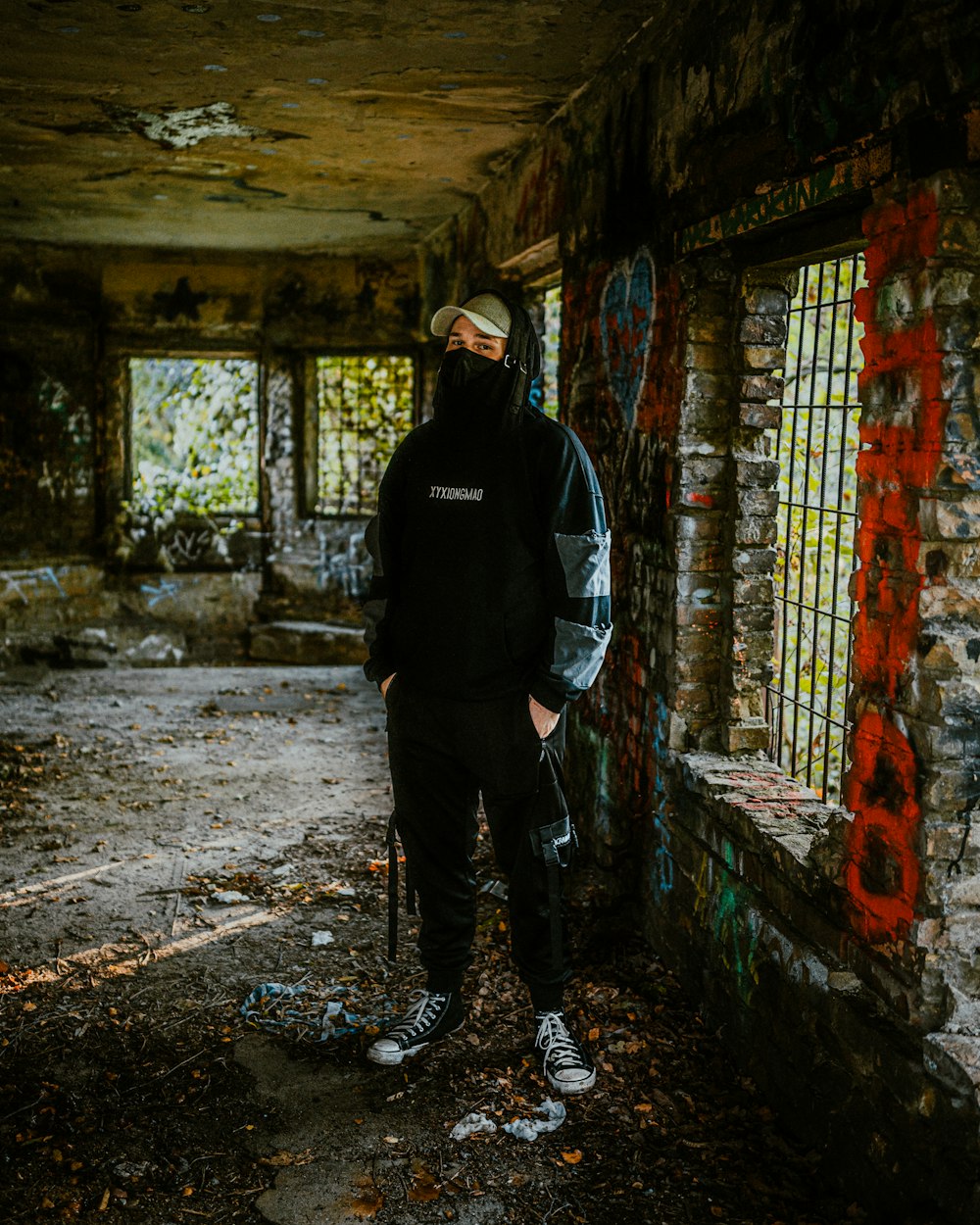 a man standing in an abandoned building with graffiti on the walls