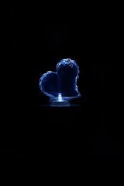Close-up of a miniature bio-artificial kidney prototype glowing softly against a granite and blue background.