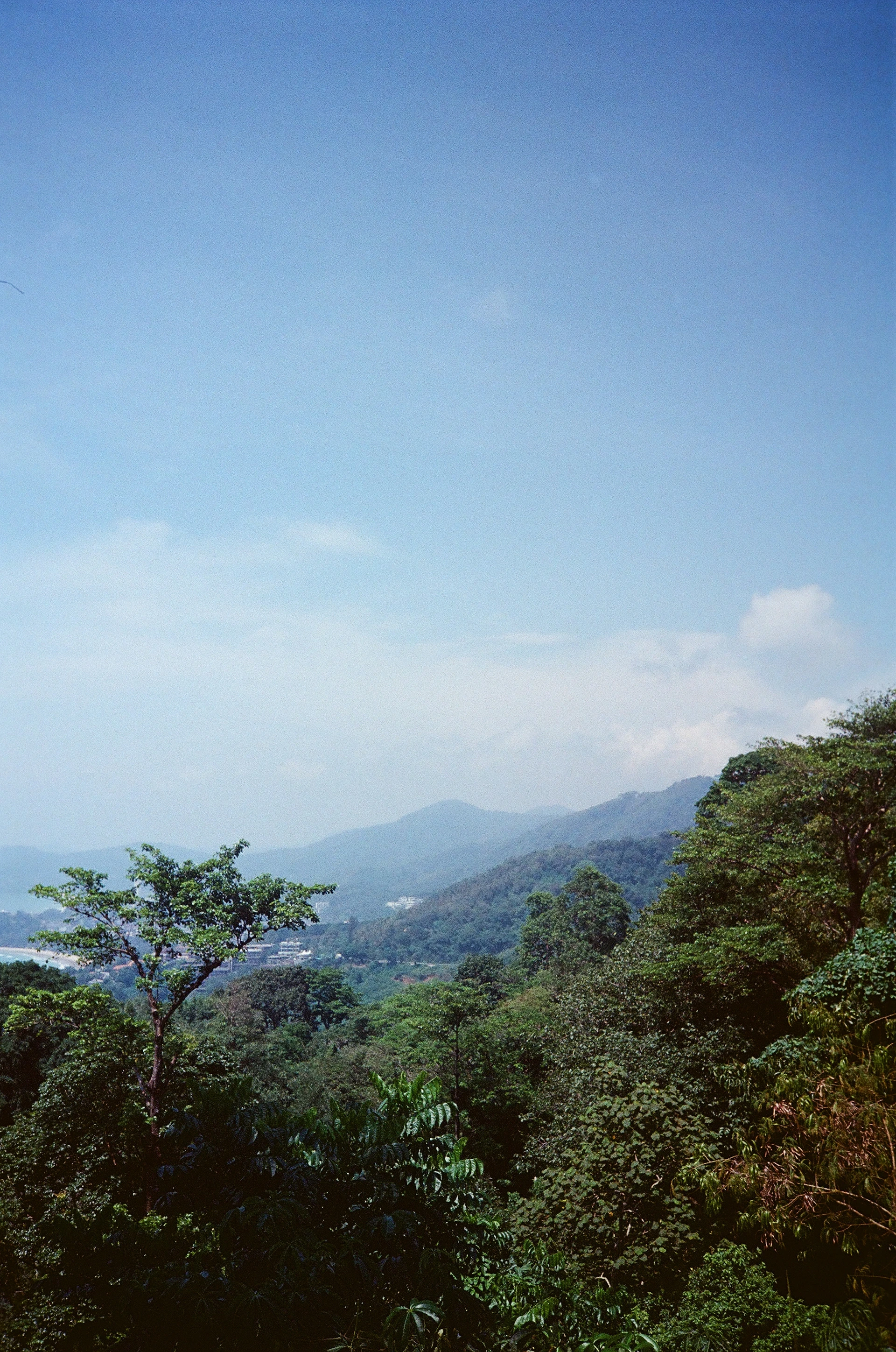 A panoramic view capturing the lush green mountains surrounding Vistamar Residences under a clear blue sky.