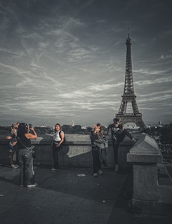 A group photo of happy tourists in front of the Eiffel Tower during a Paris tour