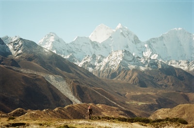 A breathtaking mountain landscape with a hiker overlooking a vast valley.