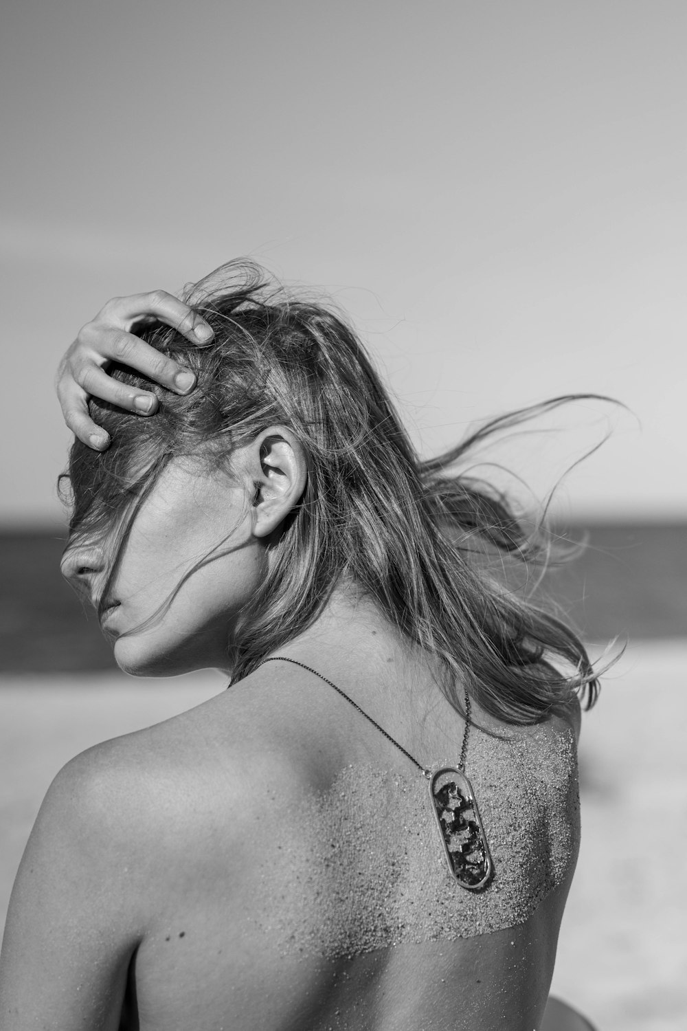 uma mulher com uma tatuagem nas costas na praia