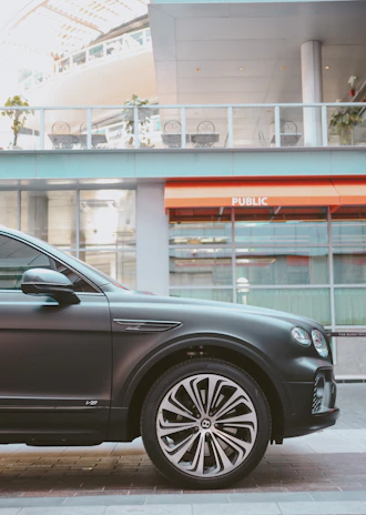 A luxury sedan with refined reflections and color correction parked in an urban setting.