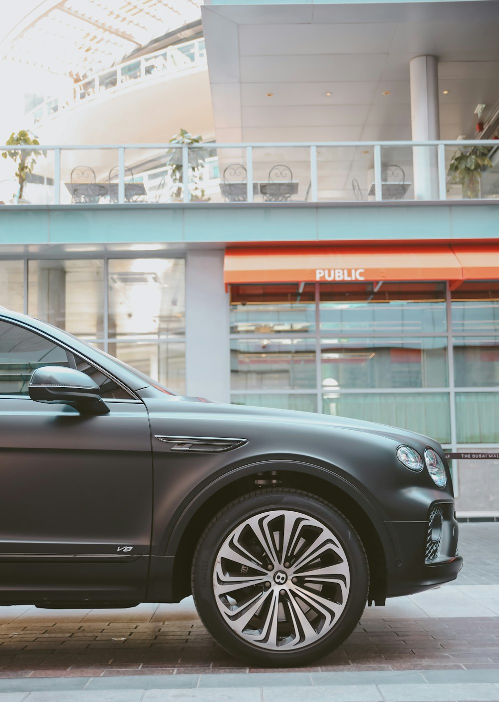 a grey car parked in front of a building