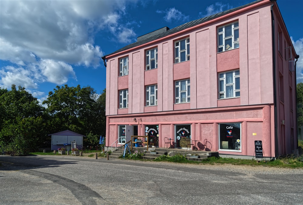 a pink building sitting on the side of a road