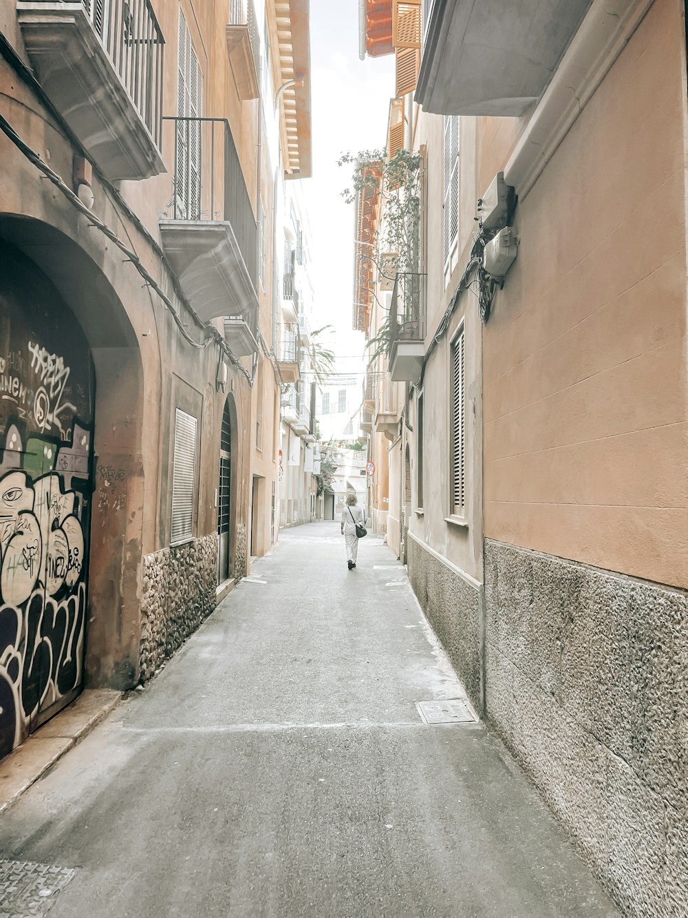 a person walking down a narrow alley way