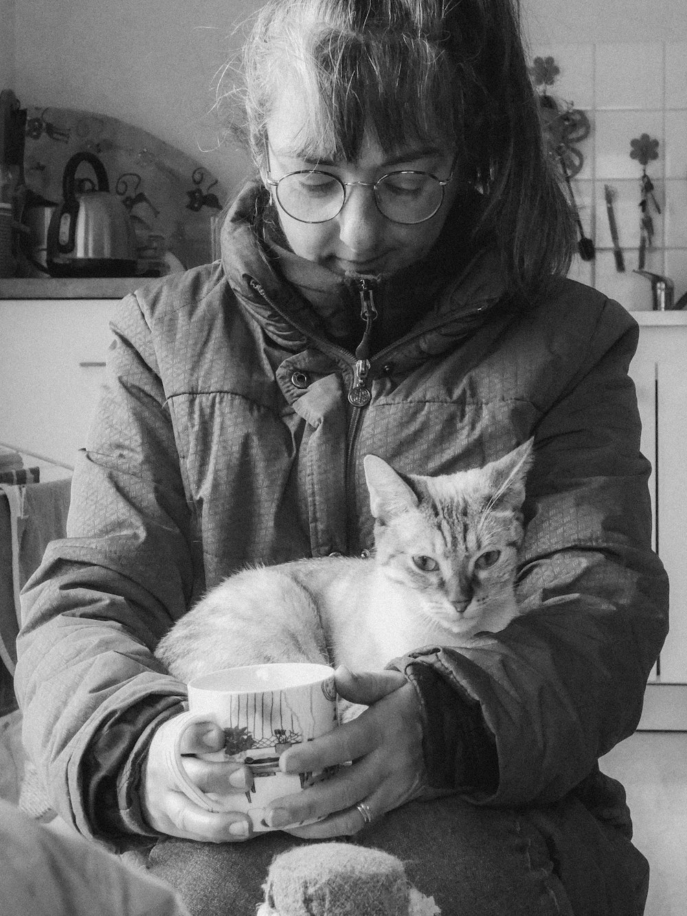 a black and white photo of a woman holding a cat