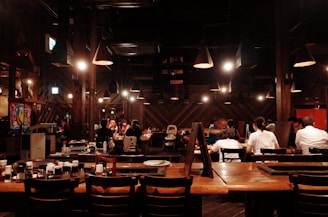 A warmly lit dining area with guests enjoying their dinner in a friendly atmosphere.