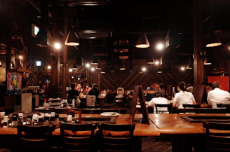 A cozy Scandinavian-style restaurant with warm lighting and a team discussing social media plans around a wooden table.
