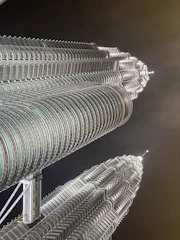 A stunning aerial view of BPTP Skynest's twin towers piercing the Faridabad skyline at sunset.