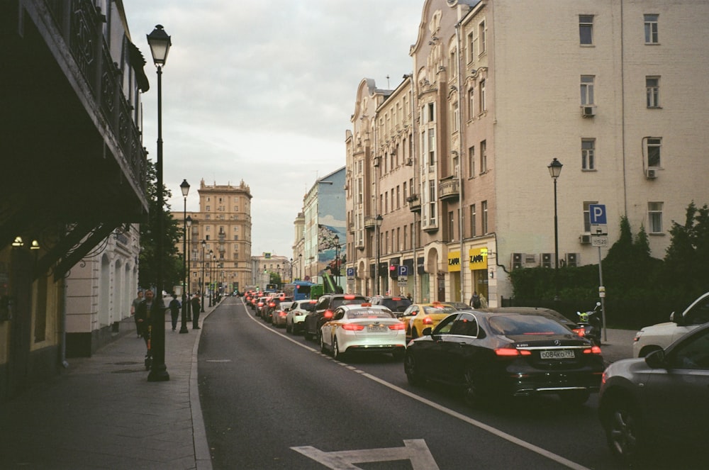 a street filled with lots of traffic next to tall buildings