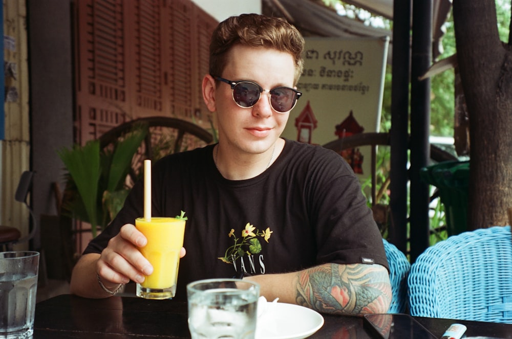 a man sitting at a table with a drink in front of him