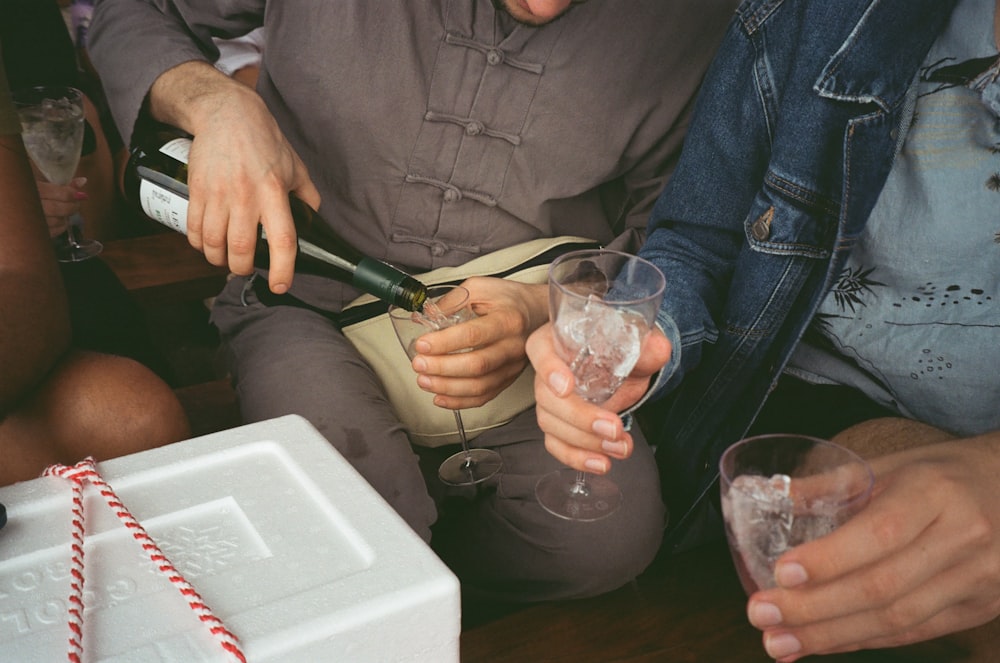 a group of people sitting around drinking wine