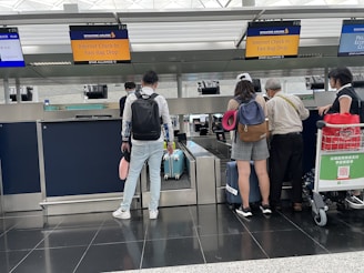 Smiling travelers checking their plane tickets at an airport terminal