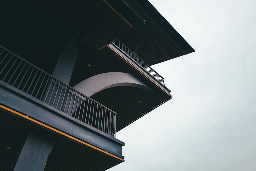 Close-up of a sleek, modern home framing under construction with charcoal and gold accents in the background.