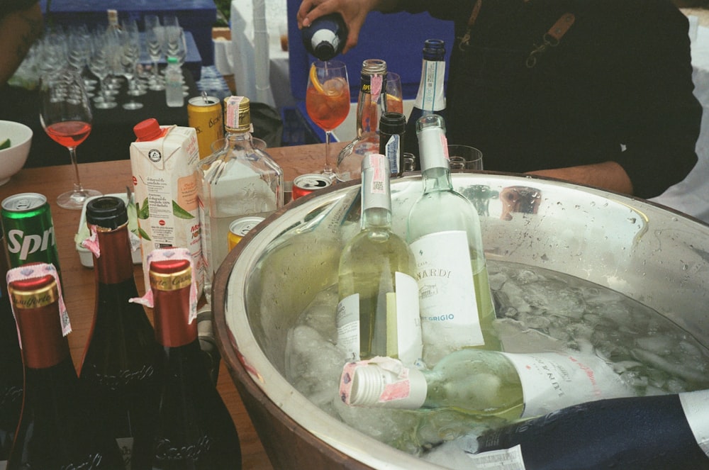 bottles of wine are being poured into an ice bucket