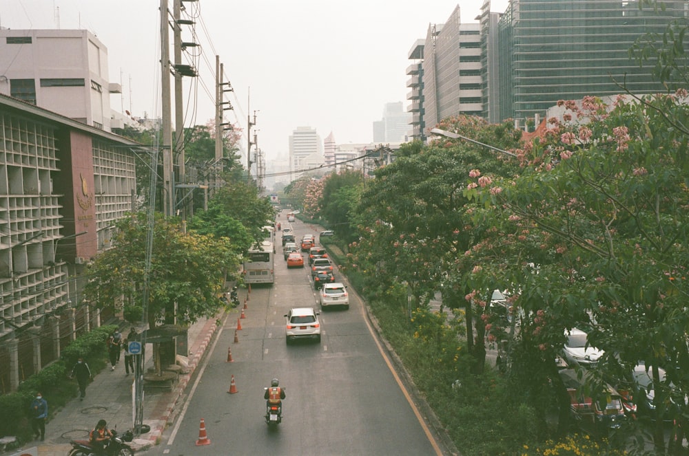 a city street filled with traffic next to tall buildings