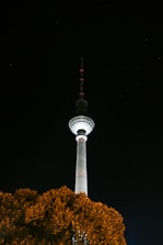 Close-up of the navy blue battery base of a solar lighting tower glowing softly in the night.