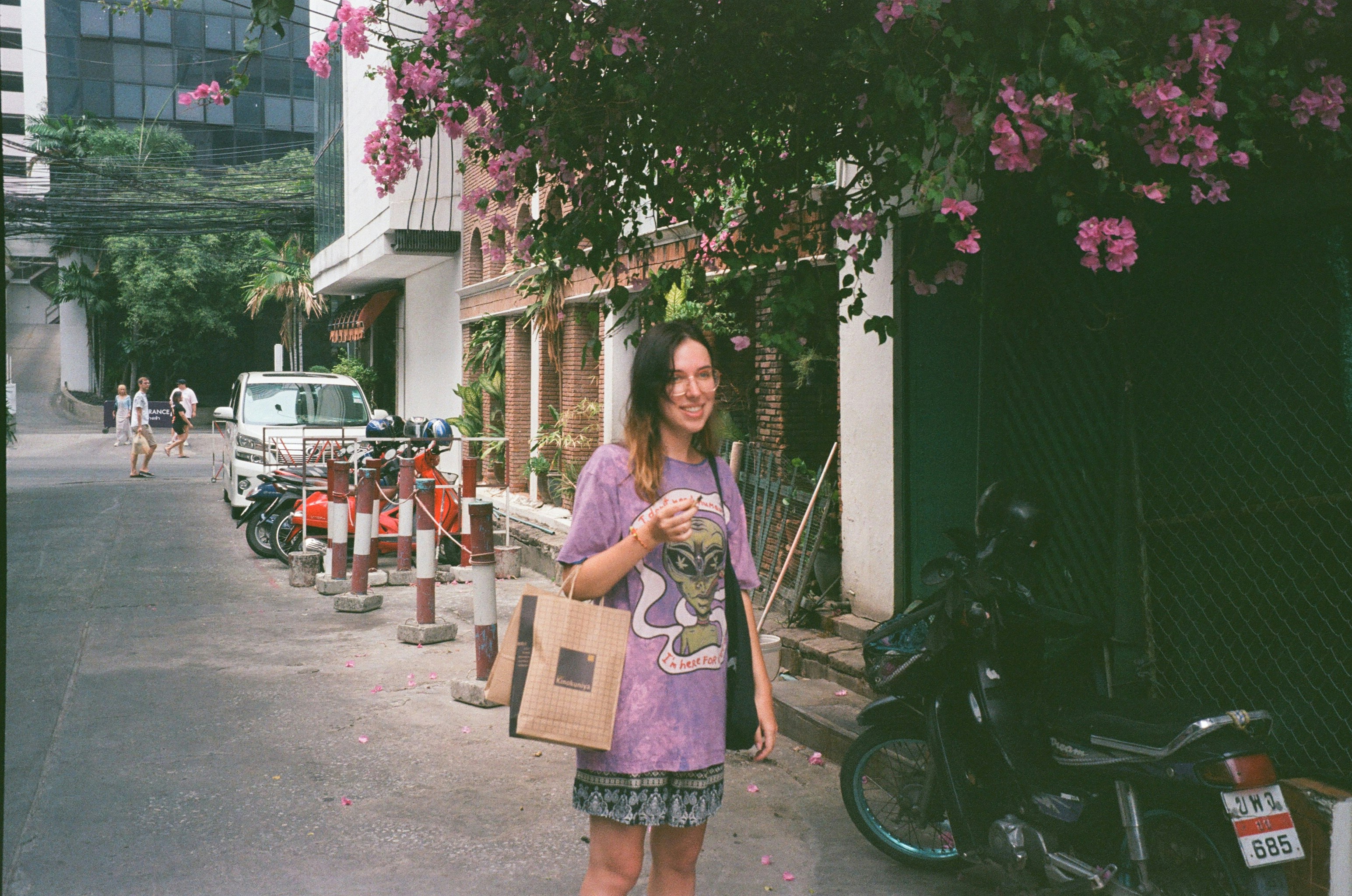 a woman standing on a street holding a bag