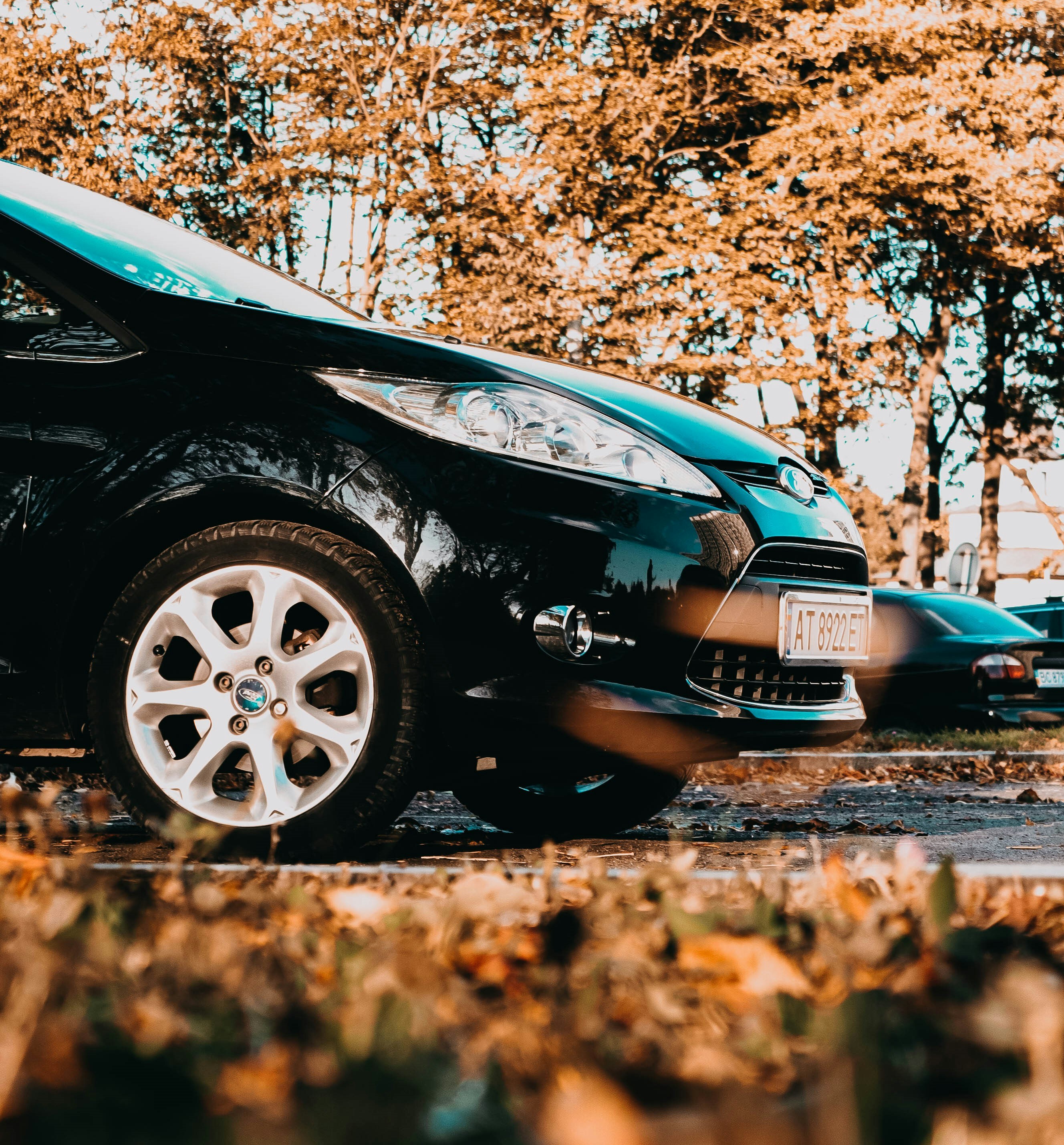 a small black car parked in a parking lot