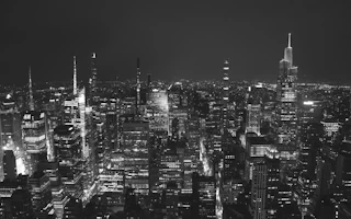 An urban cityscape artwork showcasing a bustling street at night.