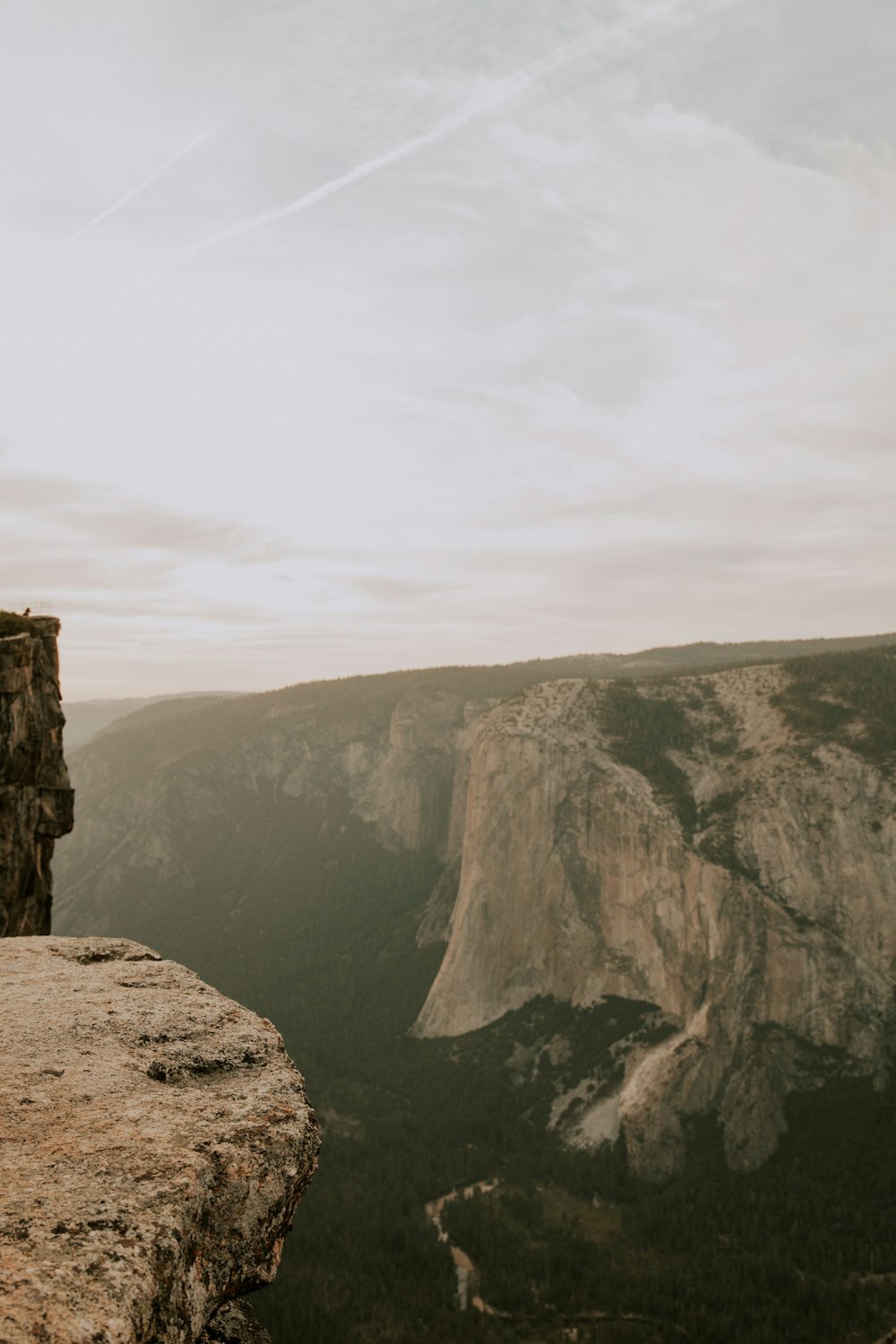 a person standing on a cliff overlooking a valley